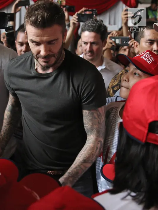 Mantan bintang sepak bola Inggris David Beckham menyapa anak-anak pada acara AIA Sepak Bola untuk Negeri di Jakarta, Minggu (25/3). Kegiatan David membagikan 10 ribu bola untuk anak-anak memecahkan rekor MURI. (Liputan6.com/Herman Zakharia)