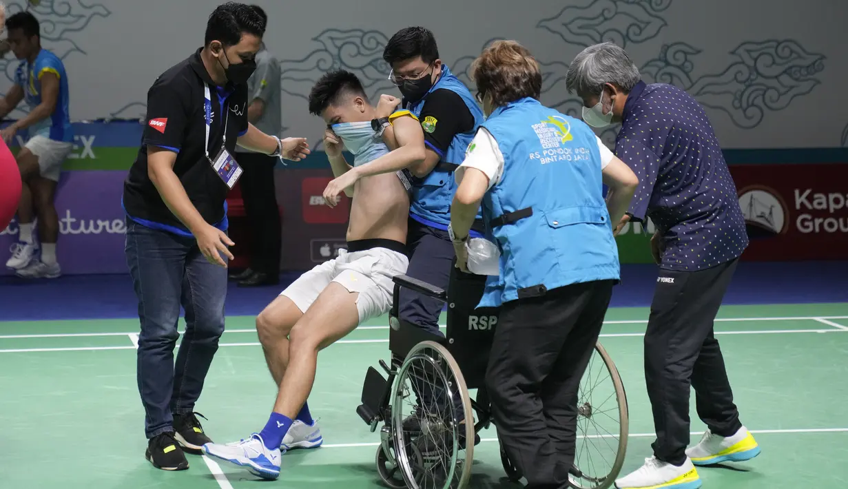 Ganda putra Indonesia Yeremia Rambitan dibawa ke kursi roda setelah cedera saat pertandingan perempat final dengan rekannya Pramudya Kusumawardana melawan pasangan Malaysia Aaron Chia/Soh Wooi Yik di Istora Senayan, Jakarta, Jumat (17/6/2022). Yeremia lalu harus meninggalkan lapangan dengan kursi roda. (AP Photo/Dita Alangkara)