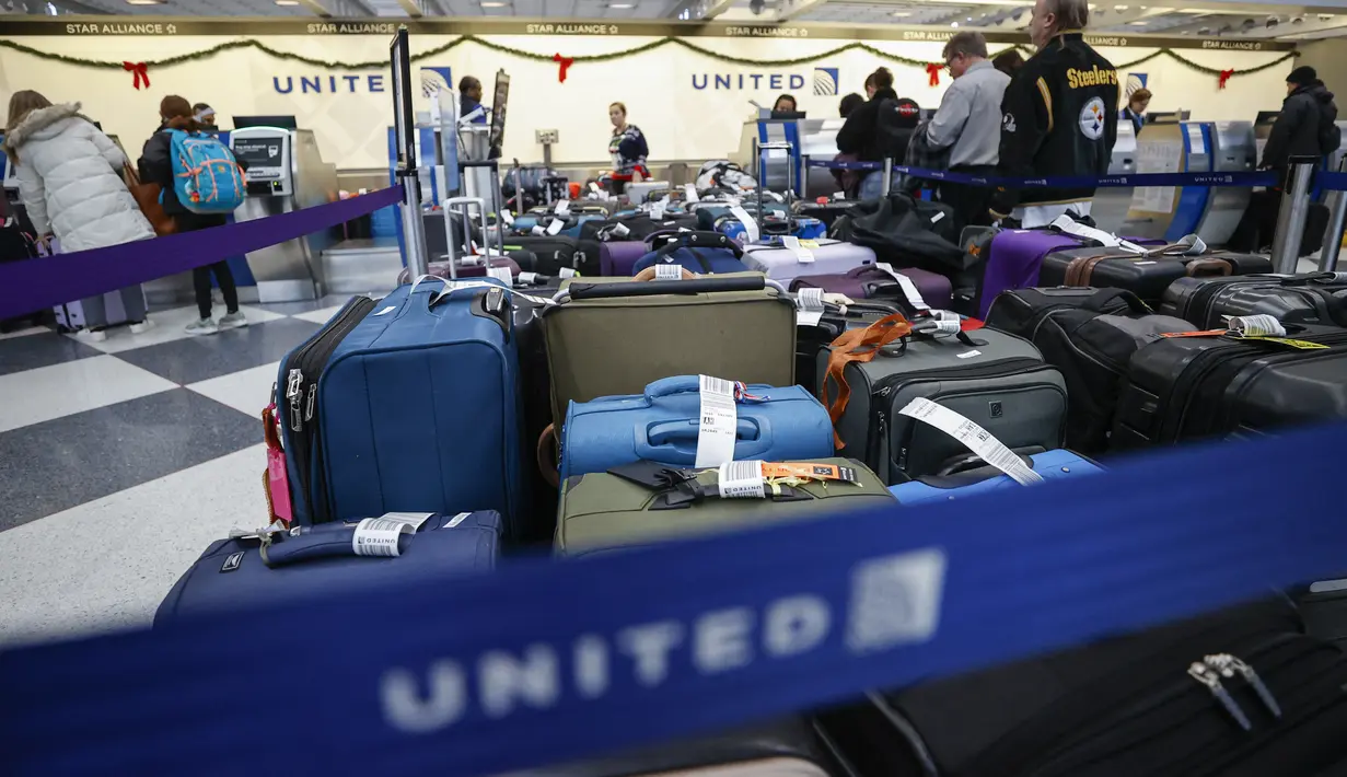 Sejumlah koper penumpang terlih di Terminal 1 United Airlines menjelang Liburan Natal di Bandara Internasional O'Hare di Chicago, Illinois (22/12/2022). Lebih dari 1.500 penerbangan dibatalkan di seluruh AS pada Kamis pagi karena badai musim dingin yang dahsyat membalikkan rencana perjalanan liburan dengan ancaman tiga kali lipat dari salju tebal, angin menderu, dan dingin yang menggigit. (AFP/Kamil Krzaczynski)