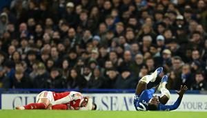 Pemain Arsenal, Mikel Merino (kiri) mengeram kesakitan setelah dilanggar oleh pemain Chelsea, Moises Caicedo dalam laga lanjutan Liga Inggris 2025/2026 di Stamford Bridge, London, Minggu (30/11/2025). (AFP/Justin Tallis)