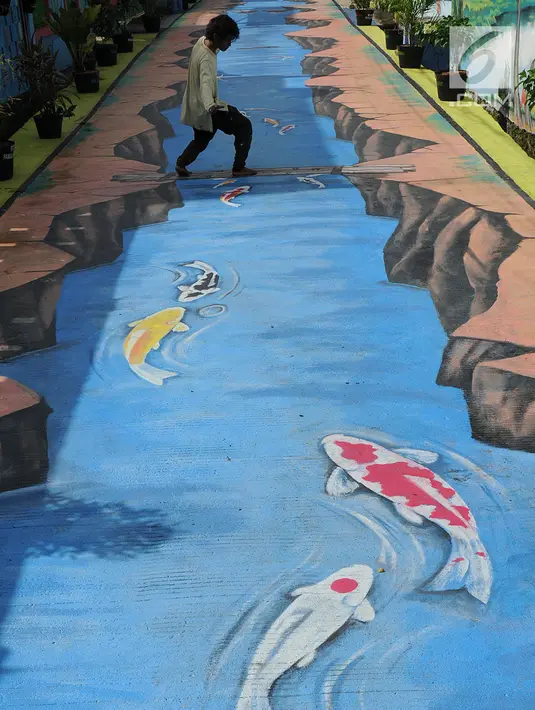 Seorang pria bergaya di atas lukisan tiga dimensi atau 3D yang menghiasi aspal Jalan Husada, Pamulang, Tangerang Selatan, Selasa (27/3). Lukisan 3D ini dibuat warga untuk mengekspresikan keindahan serta tempat berswafoto. (Merdeka.com/Arie Basuki)