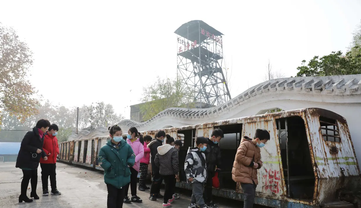 Para wisatawan mengamati gerbong trem di Tambang Wangfeng di Distrik Zhongzhan, Kota Jiaozuo, Provinsi Henan, China tengah (29/11/2020). Tambang Wangfeng yang berlokasi di Distrik Zhongzhan, Kota Jiaozuo, dioperasikan pada 1919 dan memiliki sejarah lebih dari 100 tahun. (Xinhua/Feng Xiaomin)