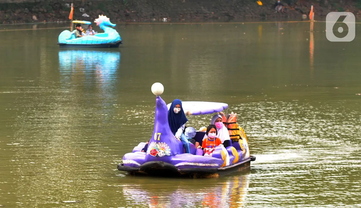 Warga berkeliling dengan menggunakan perahu wisata di Setu Babakan, Jagakarsa, Jakarta Selatan, Minggu (4/4/2021). Setu Babakan kembali dibuka untuk umum pada 27 Maret 2021 dengan menerapkan protokol kesehatan. (merdeka.com/Arie Basuki)