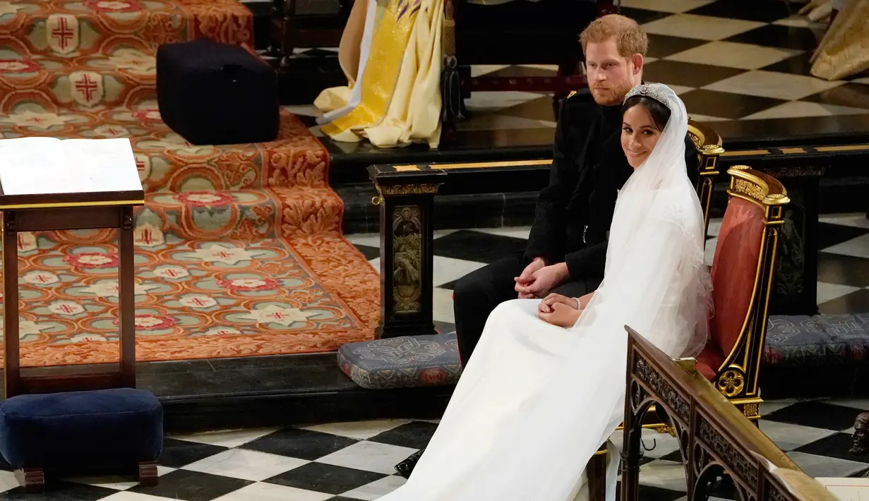 Pangeran Harry duduk bersama Meghan Markle saat prosesi pernikahan mereka di Kapel St. George, Kastil Windsor, Inggris, Sabtu (19/5). Pangeran Harry dan Meghan Markle resmi menjadi suami istri. (Owen Humphreys/POOL/AFP)