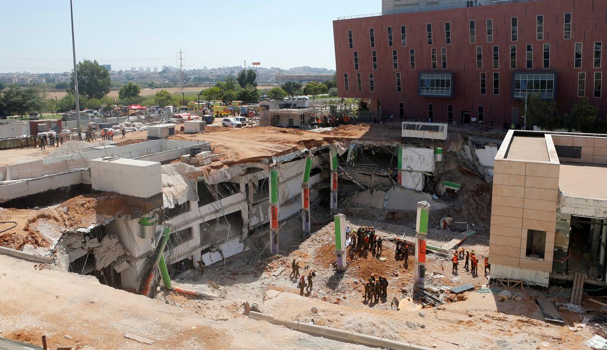 Petugas regu penyelamat dikerahkan mencari warga yang hilang di reruntuhan gedung parkir yang ambruk di Tel Aviv, Israel, Senin (5/9). Dua orang tewas dan lainnya hilang akibat ambruknya gedung parkir yang sedang dibangun tersebut. (REUTERS/Nir Elias)