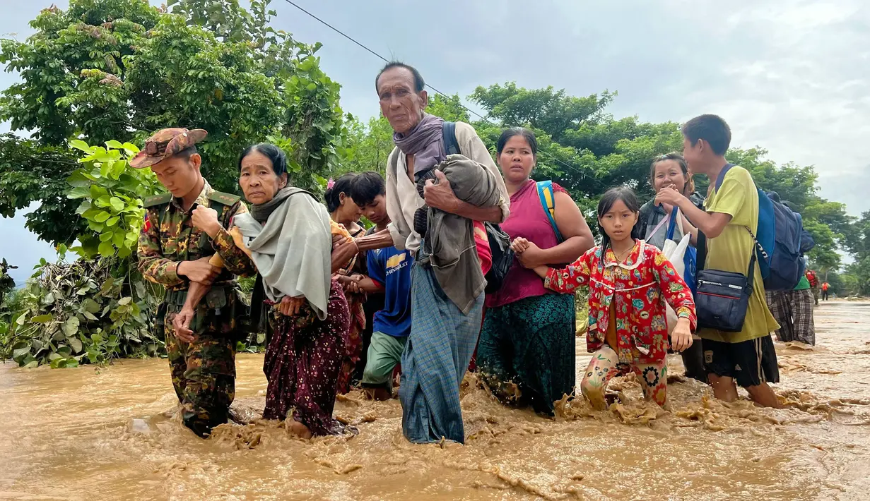 Warga berjalan melintasi banjir di Pyinmana di wilayah Naypyidaw, Myanmar, pada tanggal 13 September 2024. (Sai Aung MAIN/AFP)