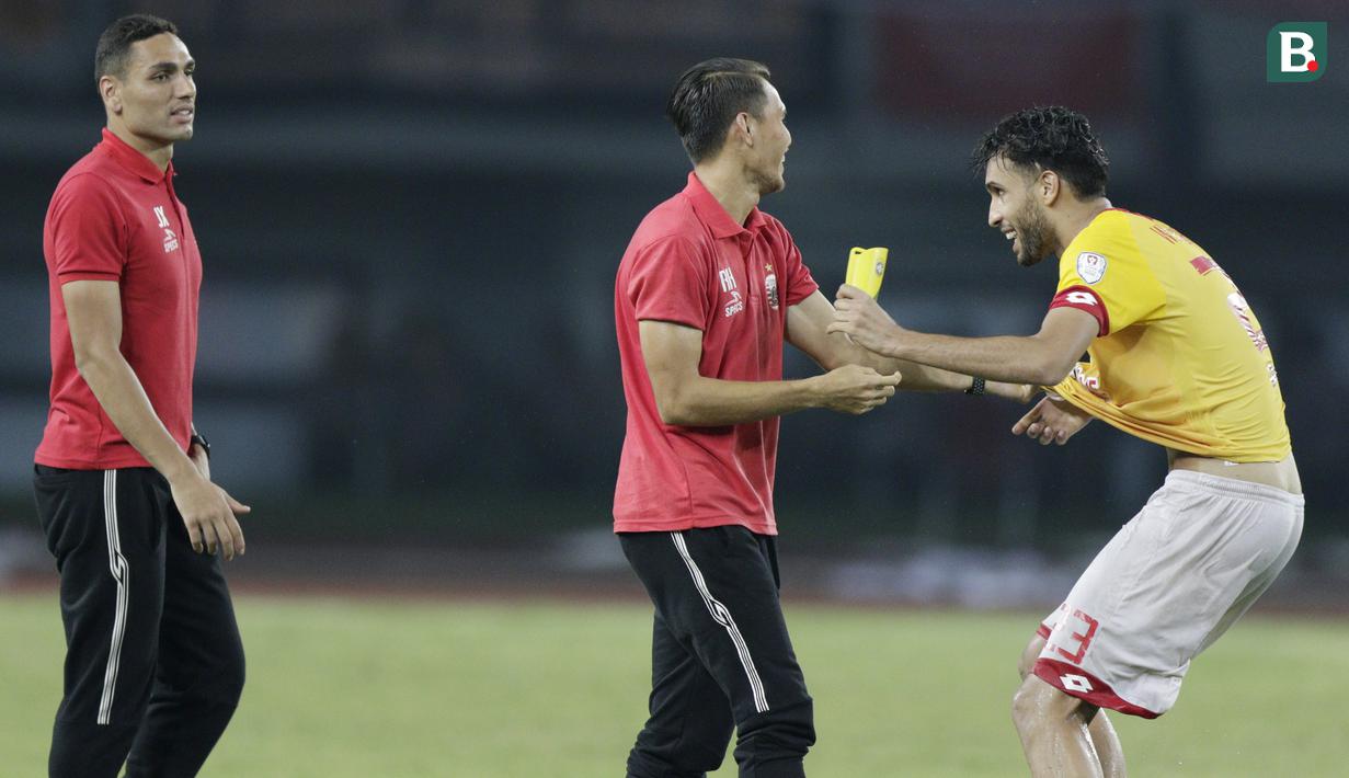 Bek Selangor FA, Willian Pachecho, bercanda dengan pemain Persija Jakarta, Rezaldi Hehanusa, pada laga persahabatan di Stadion Patriot, Jawa Barat, Kamis (6/9/2018). Persija kalah 1-2 dari Selangor FA. (Bola.com/M Iqbal Ichsan)