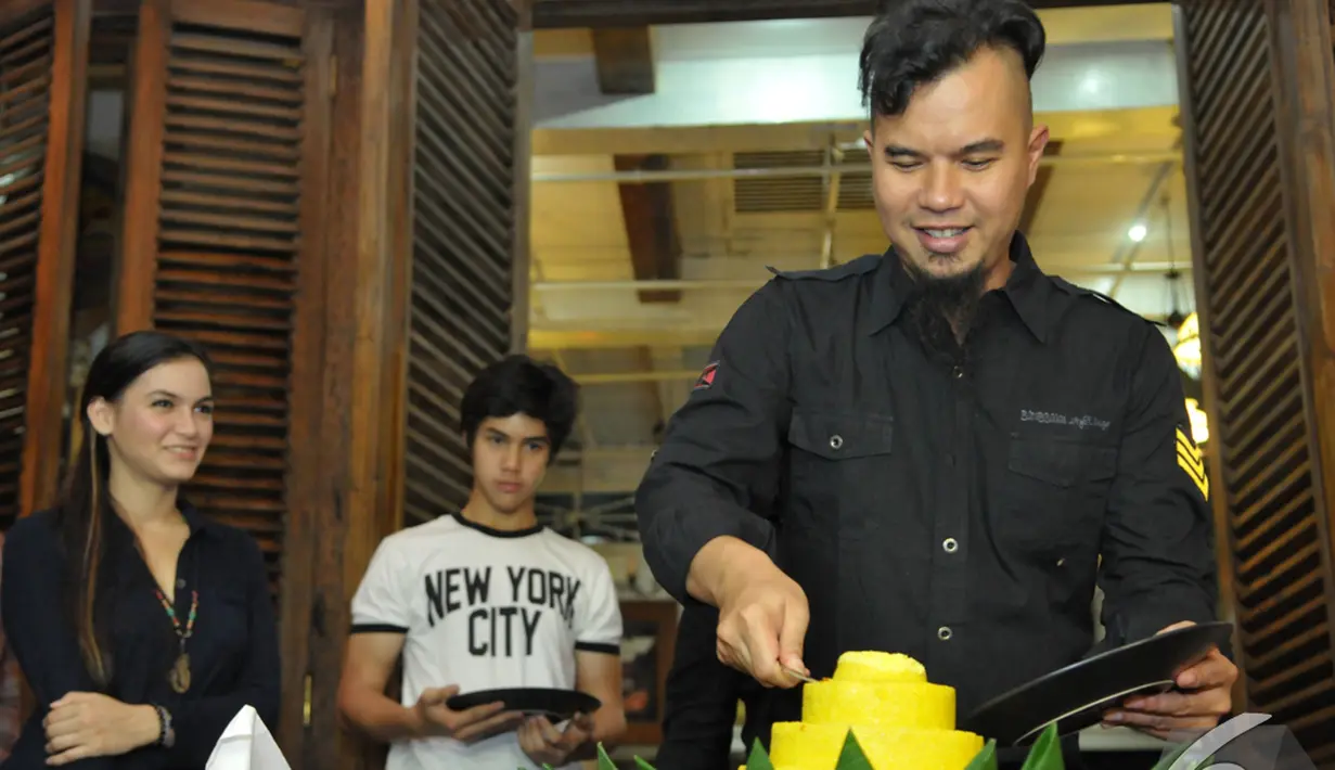 Ahmad Dhani memotong tumpeng pada acara syukuran film 'Kampung Zombie', Pondok Indah, Jakarta Selatan, Senin (7/12/2014). (Liputan6.com/Panji Diksana)