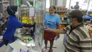 Pekerja melayani pembeli dari balik plastik pembatas pada sebuah minimarket di kawasan Cinere, Depok, Jawa Barat, Rabu (8/4/2020). Penggunaan plastik pembatas tersebut bertujuan untuk mengantisipasi penyebaran virus corona atau COVID-19 sebagai bentuk social distancing. (merdeka.com/Arie Basuki)