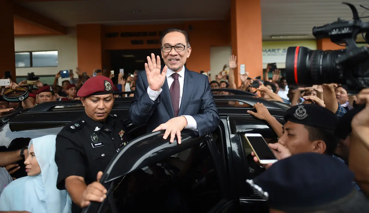 Mantan pemimpin oposisi Malaysia, Anwar Ibrahim melambaikan tangan saat keluar dari RS Rehabilitasi Cheras, Kuala Lumpur, Rabu (16/5). Anwar Ibrahim dibebaskan setelah Yang Dipertuan Agung Muhamman V memberikan pengampunan penuh. (AFP/MOHD RASFAN)