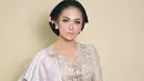 Sesekali, Krisdayanti keluar dari zona nyamannya mengenakan kebaya warna yang lebih tone down. Seperti potret ini, ia tampil memesona kenakan kebaya dan selendang kombinasi warna beige dan silver. [@krisdayantilemos].