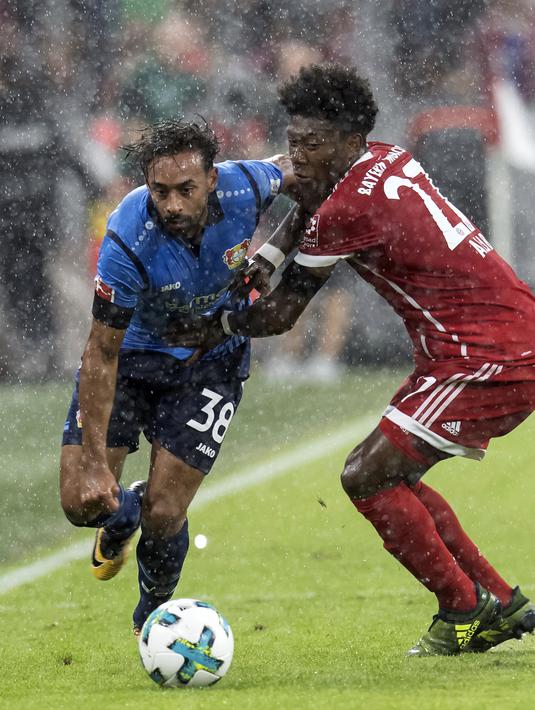 Pemain Bayern Munchen, David Alaba (kanan) berebut bola dengan pemain Leverkusen, Karim Bellarabi pada laga Bundesliga di Allianz Arena, Munich,  (18/8/2017). Bayern menang 3-1. (Sven Hoppe/dpa via AP)