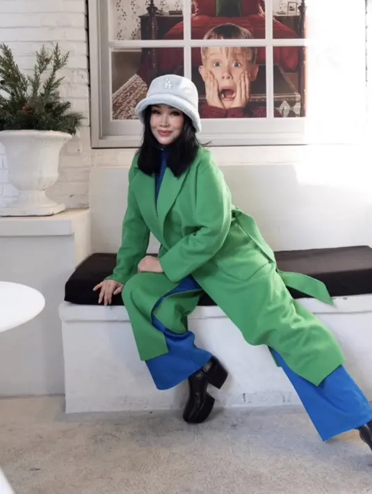 Semakin terlihat muda dengan outfit coat hijau dipadukan inner dan celana birunya. Serta bucket hat yang menutupi rambut sepundak Titi DJ. (@ti2dj)