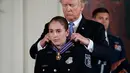Presiden Donald Trump memberikan Medali Kehormatan kepada Nicole Battaglia dari Departemen Kepolisian Alexandria, Va di Gedung Putih, Washington, (27/7). Lima perwira dapatkan penghargaan atas kasus penembakan di Virginia. (AP Photo/Evan Vucci)