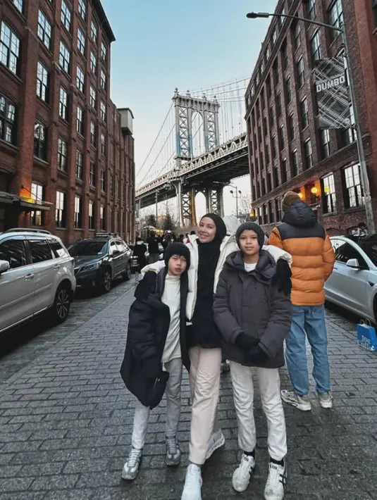 Ratna Galih juga mengajak anak-anaknya liburan ke Amerika Serikat saat musim dingin. Ia tampil dengan padding vest putih dipadukan kerudung dan inner kaos hitam serta bawahan celana panjang ivory. [@ratnagalih]