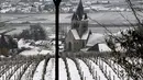 Gereja Ville-Dommange dikelilingi oleh kebun anggur sampanye yang tertutup salju pada hari pertama musim semi di wilayah Champagne di Mailly-Champagne, dekat Reims, (19/3). (AFP Photo/Francois Nascimbeni)