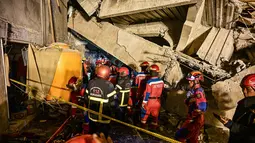 Petugas penyelamat mencari korban selamat di antara reruntuhan salah satu bangunan di sebuah pondok pesantren, Sidoarjo, Jawa Timur, pada Senin 29 September 2025 sore. (Juni Kriswanto/AFP)