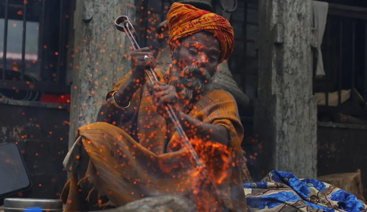 Seorang sadhu (lelaki suci Hindu) membuat api untuk menghangatkan dirinya selama festival Shivaratri di lokasi kuil Pashupatinath di Kathmandu, Nepal (20/2/2020). Festival ini  didedikasikan untuk 'Malam Besar Siwa', dewa Hindu yang berdoa dan berpuasa bagi orang percaya. (AP/Niranjan Shrestha)