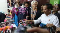 Presiden Joko Widodo (Jokowi) mengajak Direktur Pelaksana IMF Christine Lagarde memilih batik saat mengunjungi  Blok A Pasar Tanah Abang, Jakarta, Senin (26/2). Keduanya meninjau beberapa kios sambil berbincang dengan penjual. (Liputan6.com/Angga Yuniar)