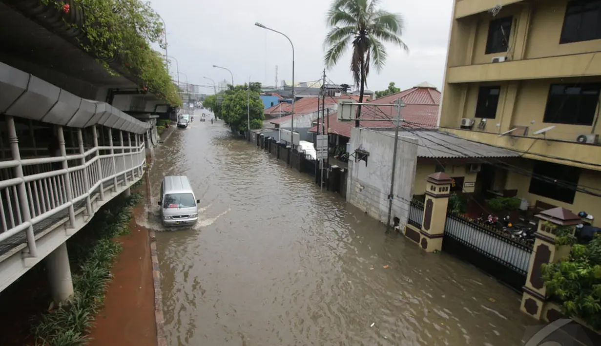 Hujan yang mengguyur sejak pagi tadi menyebabkan genangan di beberapa ruas jalan Ibukota Jakarta, Sabtu (27/12/2014). (Liputan6.com/Miftahul Hayat)