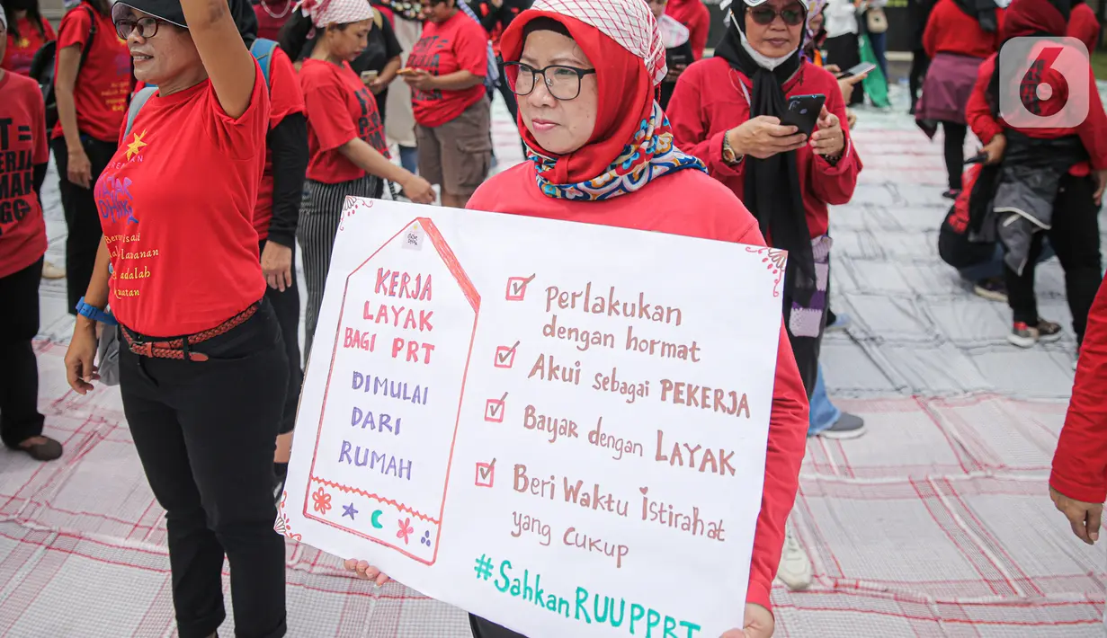 Salah satu peserta aksi yang tergabung dalam Koalisi Sipil Untuk UU Perlindungan PRT mengangkat poster di depan Gedung DPR, Jakarta, Rabu (15/7/2023). Dalam aksinya, pendemo yang sebagian besar ibu-ibu ini juga membawa spanduk dan poster berisi tuntutan mereka. (Liputan6.com/Faizal Fanani)