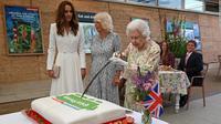 Ratu Elizabeth II memotong kue menggunakan pedang (AFP)