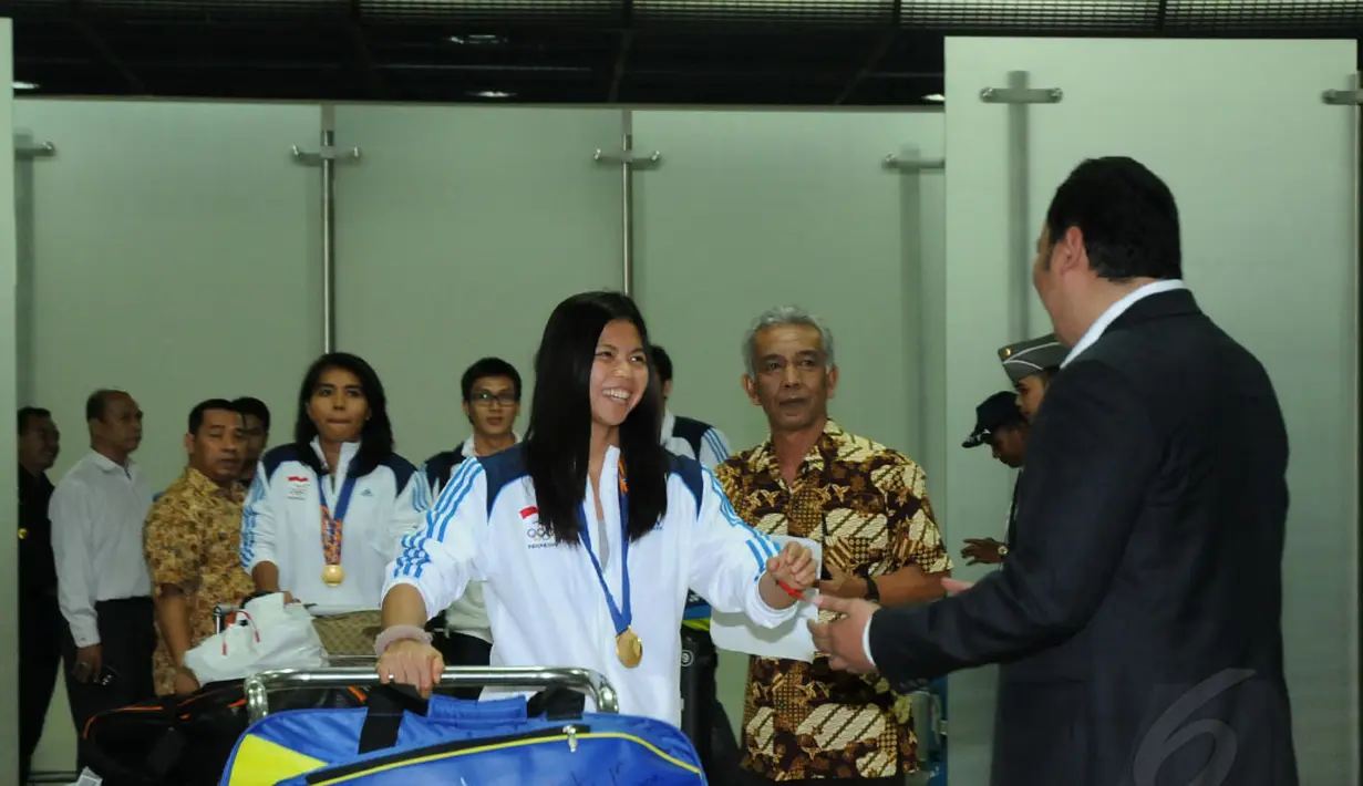 Usai berlaga di Asian Games 2014, tim bulutangkis Indonesia kembali ke tanah air dan tiba di Bandara Soekarno-Hatta pada Selasa, (30/9/2014). (Liputan6.com/Helmi Fithriansyah)
