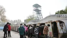Para wisatawan mengamati gerbong trem di Tambang Wangfeng di Distrik Zhongzhan, Kota Jiaozuo, Provinsi Henan, China tengah (29/11/2020). Tambang Wangfeng yang berlokasi di Distrik Zhongzhan, Kota Jiaozuo, dioperasikan pada 1919 dan memiliki sejarah lebih dari 100 tahun. (Xinhua/Feng Xiaomin)