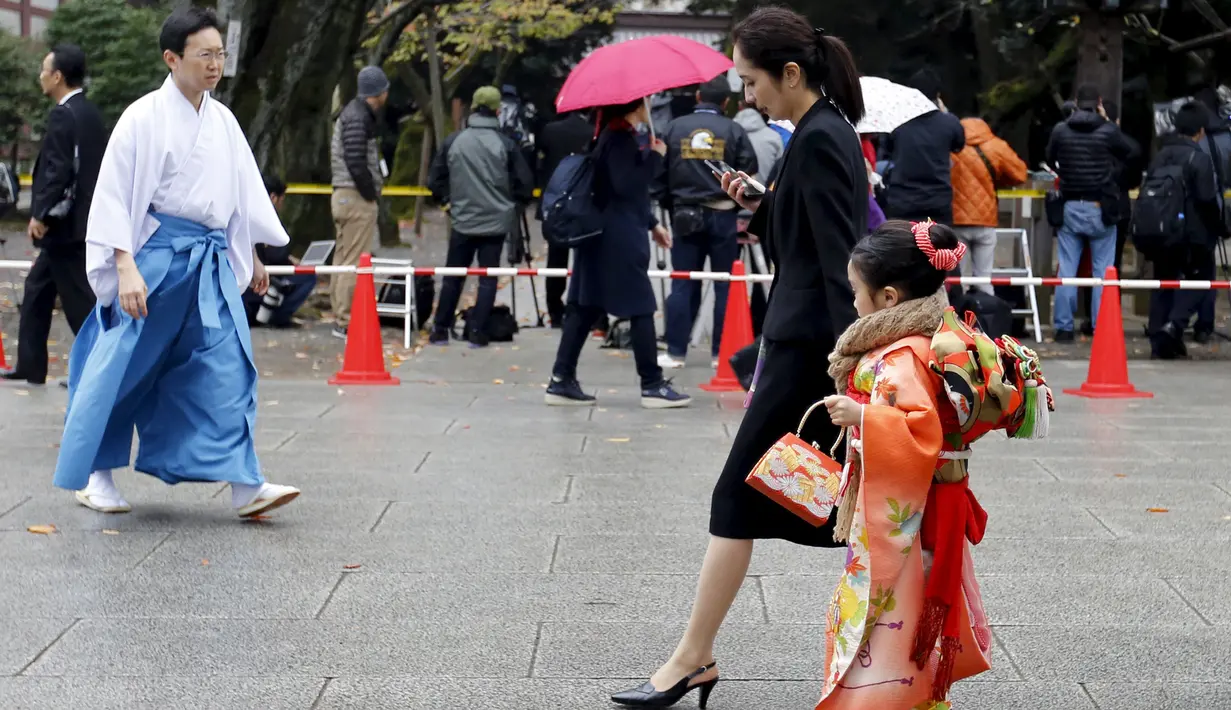 Seorang gadis mengenakan Kimono mengunjungi kuil Yasukuni untuk merayakan Shichi -Go - San saat bom meledak di kuil Yasukuni di Tokyo, Jepang, (23/11). Kuil ini merupakan simbol militerisme Jepang di masa lalu (REUTERS/Kyodo)