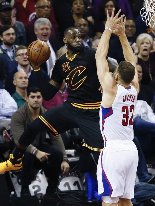 Aksi pemain Cleveland Cavaliers, LeBron James #23 mengamankan bola sebelum out saat dihadang pemain Los Angeles Clippers, Blake Griffin #32 pada laga NBA 2016-2017 di Quicken Loans Arena, (1/11/2016). (AP/Ron Schwane)