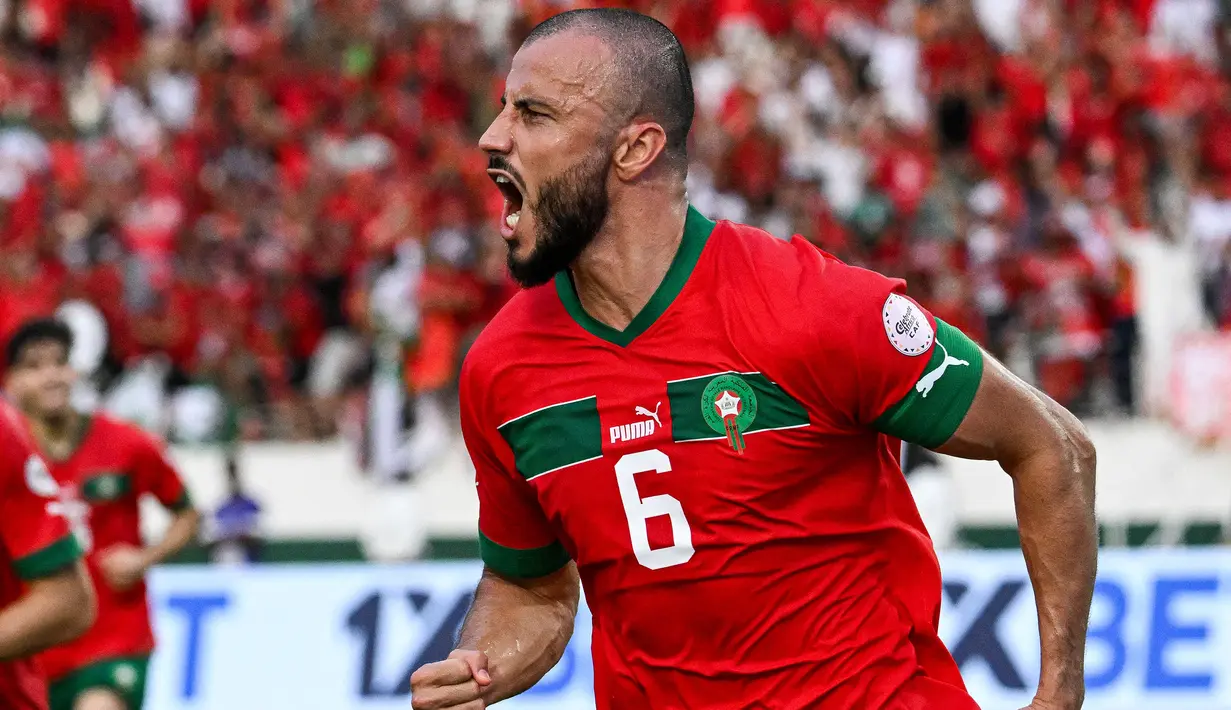 Kapten Timnas Maroko, Roman Saiss yang kini tengah menjalani musim pertama bersama klub Arab Saudi, Al Shabab dengan status pinjaman dari klub Qatar, Al Sadd SC telah mencetak 1 gol dalam 2 laga di fase Grup F Piala Afrika 2023. Satu gol tersebut dicetaknya saat Maroko menang 3-0 atas Tanzania pada laga pertama (17/1/2024). (AFP/Sia Kambou)