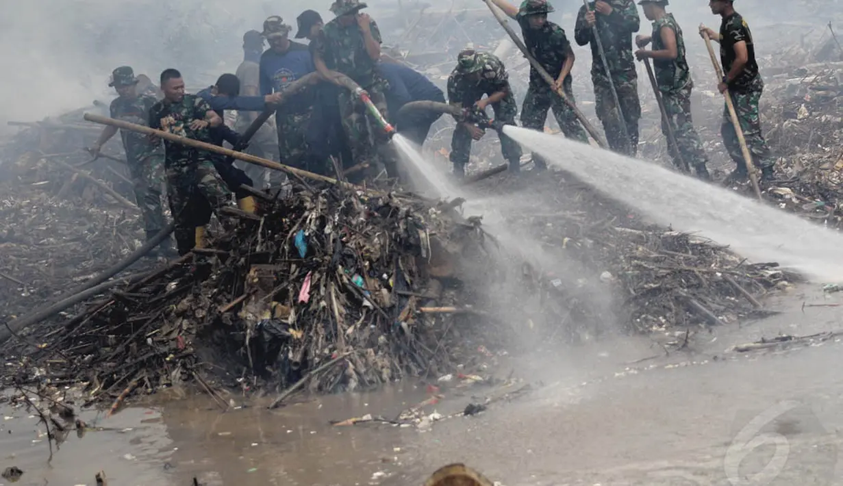 Personel TNI bersama pemadam kebakaran dan masyarakat membersihkan sampah Sungai Ciliwung, Kampung Melayu, Jakarta, Selasa (2/12/2014). (Liputan6.com/Faizal Fanani)