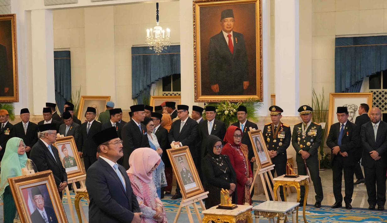 Soeharto dikategorikan sebagai pahlawan bidang perjuangan. Tampak dalam foto, potret besar mendiang Presiden ke-2 RI, Suharto, terpajang di dinding Istana Negara saat upacara penganugerahan gelar pahlawan nasional kepada sepuluh tokoh di Istana Negara, Jakarta, Senin 10 November 2025. (AP Photo/Achmad Ibrahim)