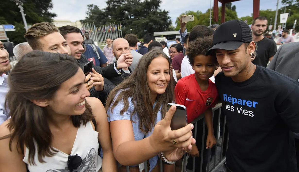 Bintang Paris Saint-Germain, Neymar Jr, foto bersama penggemarnya usai menghadiri konferensi pers di Kantor PBB, Jenewa, (15/8/2017). Neymar Jr akan fokus membantu penyandang disabilitas dan terpuruk dalam kemiskinan. (AP/Laurent Gillieron)