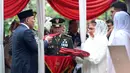 Menteri Pertahanan Sjafrie Sjamsoeddin (kiri) menyerahkan bendera Merah Putih kepada istri Jenderal TNI (Purn) Ryamizard Ryacudu di Taman Makam Pahlawan Nasional, Kalibata, Jakarta, Senin (1/6/2026). (Kapanlagi.com/Budy Santoso)