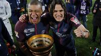 Pemain PSG, Edinson Cavani (kanan) dan Kylian Mbappe memegang Coupe De La Ligue usai kalahkan AS Monaco di Stade Matmut Atlantique, Bordeaux, Sabtu (31/3/2018) waktu setempat. PSG menang 3-0. (AP/Thibault Camus)