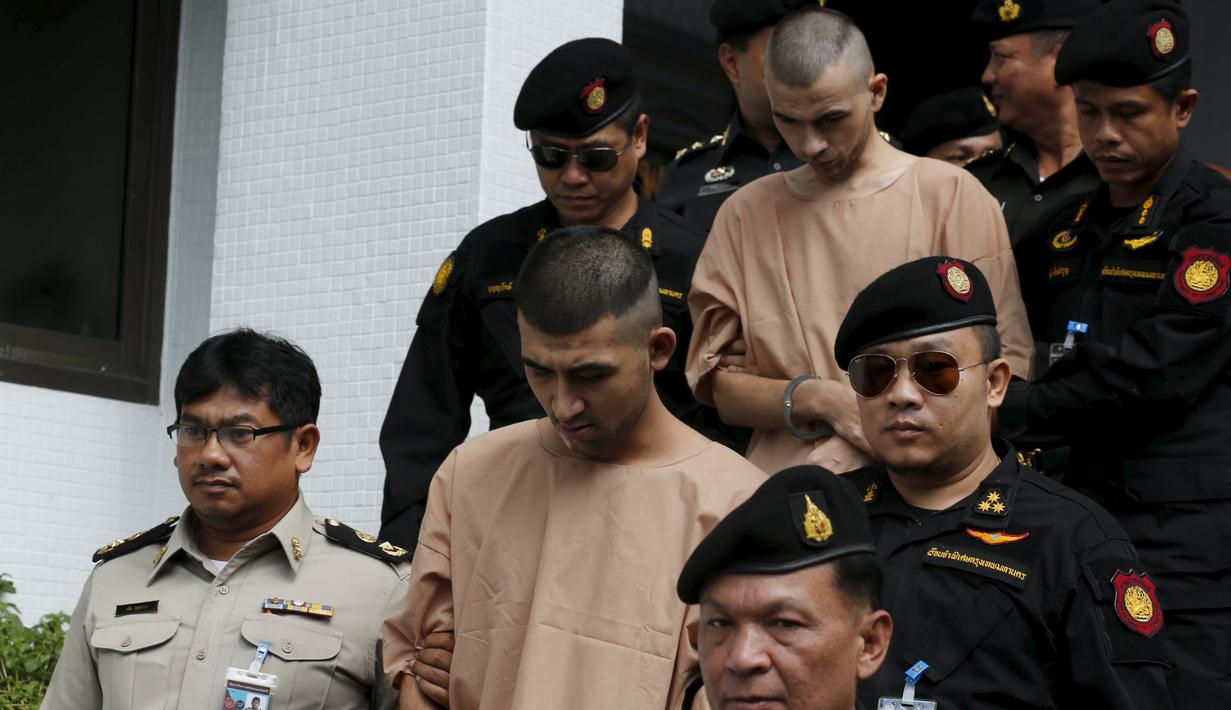 Dua tersangka pemboman Yusufu Mieraili dan Bilal Mohammed berjalan dikawal petugas saat meninggalkan Pengadilan militer (24/11). Pengadilan Thailand telah mendakwa dua orang yang dituduh melakukan serangan bom di Bangkok. (REUTERS /Chaiwat Subprasom)