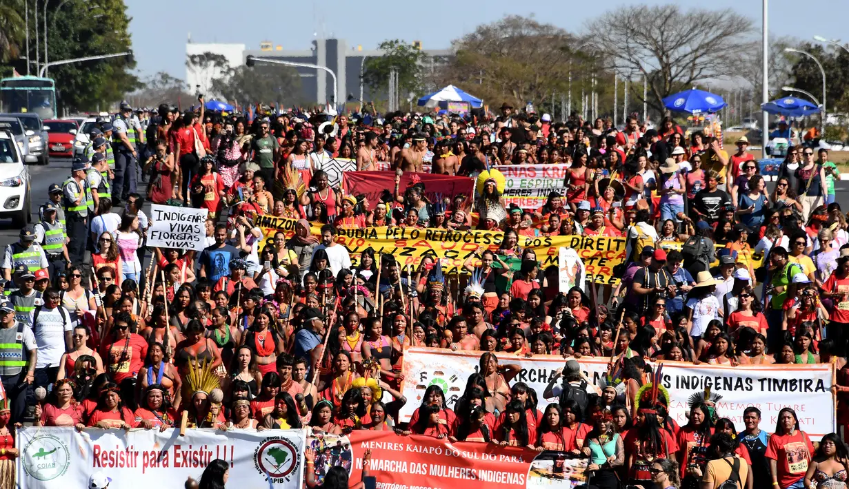 Perempuan pribumi berjalan kaki saat menggelar protes terkait kebijakan Presiden Brasil Jair Bolsonaro di Brasilia, Selasa (13/8/2019). Demonstrasi diikuti sekitar 3.000 perempuan pribumi dari seluruh Brasil. (EVARISTO SA/AFP)