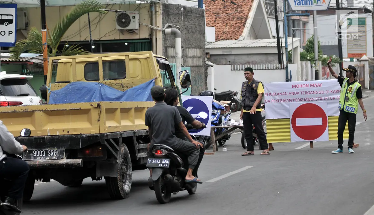 Petugas mengatur arus kendaraan saat penutupan Jalan Otista III, Jakarta, Selasa (4/12). Dinas Perhubungan DKI Jakarta menutup sementara Jalan Otista III hingga Februari 2019. (Merdeka.com/Iqbal Nugroho)