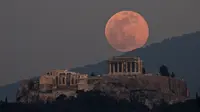 Bulan naik di atas Parthenon di Bukit Acropolis kuno di Athena, Yunani, pada 19 Februari 2019. (Petros Giannakouris/AP)