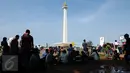 Sejumlah pengunjung beristirahat di bawah pohon yang ada di sekitar areal Monumen Nasional, Jakarta, Jumat (1/1/2016). Hari libur tahun baru 2016 dimanfaatkan ribuan warga untuk berwisata di kawasan Monumen Nasional. (Liputan6.com/Helmi Fithriansyah)