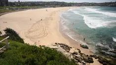 Pantai Bondi yang kosong setelah pemerintah menutup pantai paling populer di Sydney, Minggu (22/3/2020). Otoritas Australia menutup Bondi Beach  lantaran orang-orang mengabaikan larangan pemerintah untuk tidak berkumpul dalam jumlah besar guna menekan penyebaran virus corona. (PETER PARKS/AFP)