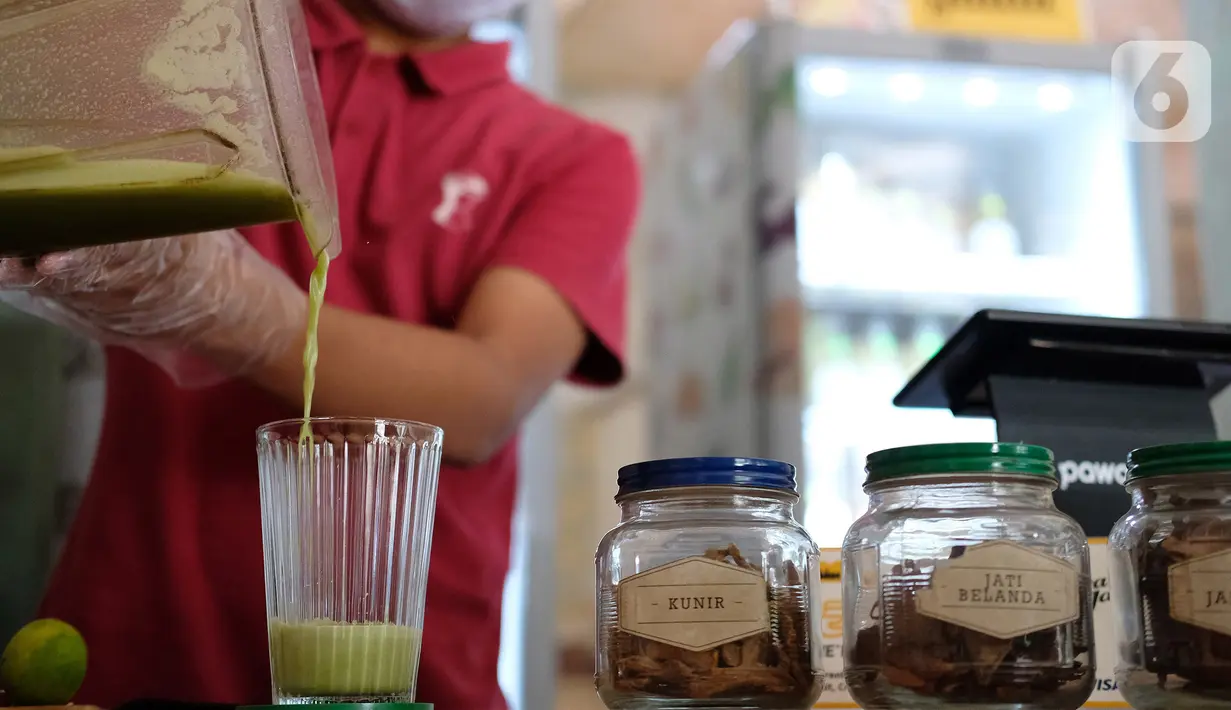 Pekerja membuat ramuan jamu tradisional di kafe Suwe Ora Jamu, kawasan M Bloc, Jakarta, Jumat (10/7/2020). Sejumlah orang masih mengonsumsi jamu sebagai salah satu cara untuk menjaga daya tahan tubuh di tengah pandemi COVID-19 seperti saat ini. (Liputan6.com/Herman Zakharia)