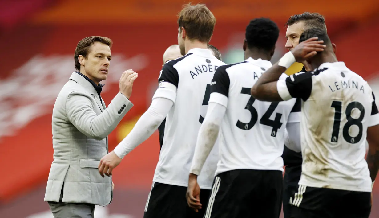 Pelatih Fulham, Scott Parker, memberikan selamat kepada anak asuhnya usai berhasil menaklukkan Liverpool pada laga Liga Inggris di Stadion Anfield, Minggu (7/3/2021). Fulham menang dengan skor 0-1. (Phil Noble/Pool/AFP)