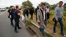 Petugas berusaha mengusir para imigran yang berusaha memasuki kawasan Channel Tunnel di Frethun, Calais, Perancis (3/8/2015). Pada malam hari imigran masuk keterowongan rel bawah laut yang menghubungkan Perancis dan Inggris. (REUTERS/Pascal Rossignol)