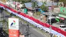 Pelajar SMA membentangkan bendera Merah Putih sepanjang 2,3 kilometer di Jalan Panjaitan dan Jalan Nani Wartabone, Gorontalo, Kamis (23/1/2020). Pembentangan bendera tersebut akan tercatat dalam Museum Rekor Indonesia (MURI). (Liputan6.com/Arfandi Ibrahim)