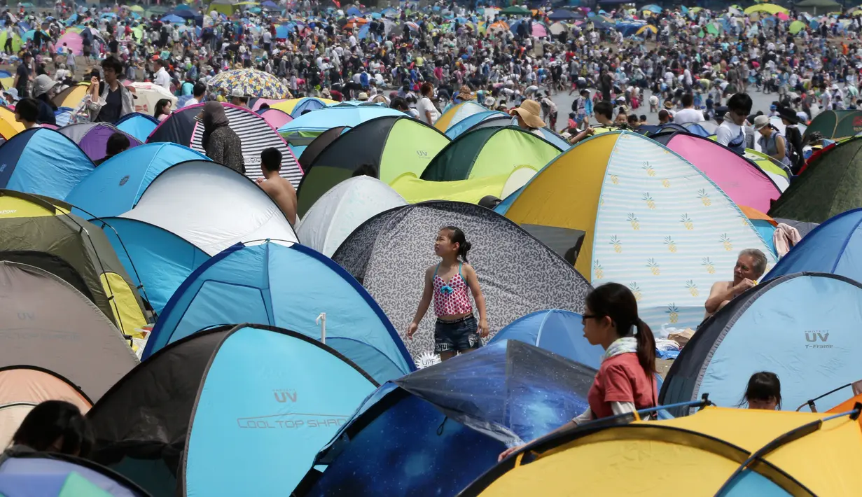 Sejumlah tenda didirikan dekat pengunjung yang berdesakan untuk berburu kerang di pantai kawasan Yokohama, dekat Tokyo, Senin (30/4). Ribuan orang membanjiri pantai selama Golden Week atau periode liburan di Jepang. (AP/Koji Sasahara)