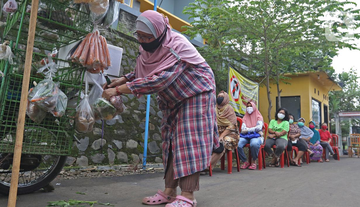 Pembeli memilih sayuran saat berbelanja di pedagang sayur keliling di Taman Anyelir 3, Depok, Selasa (28/4/2020). Warga di wilayah Taman Anyelir 3 menerapkan pembatasan jarak fisik agar tidak terjadi penumpukan pelanggan sebagai upaya pencegahan penyebaran virus corona (Liputan6.com/Herman Zakharia)