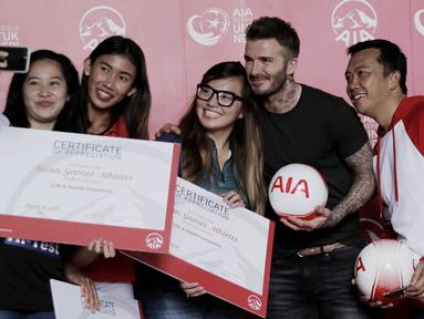 Legenda sepak bola Inggris, David Beckham, foto bersama atlet Indonesia di Stadion Soemantri Brodjonegoro, Jakarta, Minggu (25/3/2018). AIA membagikan 10.000 bola kepada akademi sepak bola di Indonesia. (Bola.com/M Iqbal Ichsan)