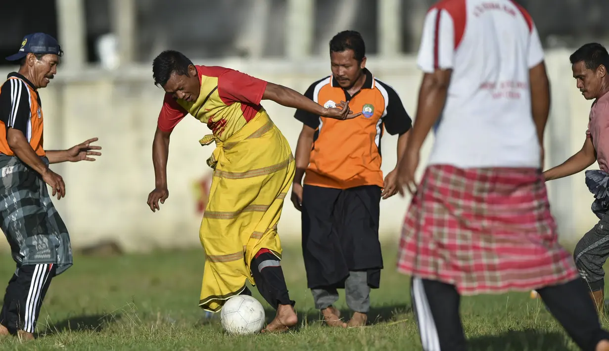 Penduduk desa bermain sepak bola dengan mengenakan sarung saat merayakan HUT ke-74 RI di Blang Pidie provinsi Aceh (17/8/2019). Indonesia merayakan kemerdekaan yang ke-74 dari pemerintahan kolonial Belanda. (AFP Photo/Chaideer Mahyuddin)